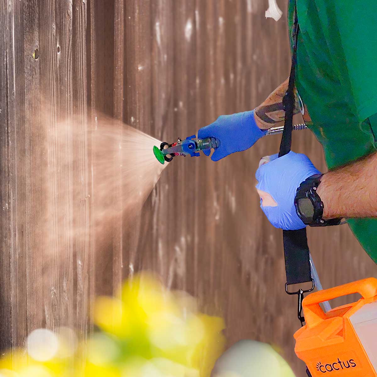 Painter sprays a garden fence with Cactus Airless Sprayer